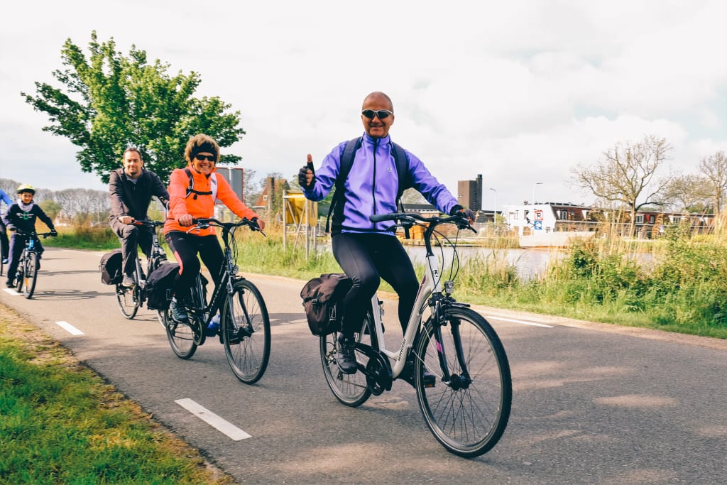 Ciclisti che pedalano su una pista ciclabile nella campagna dei Paesi Bassi, tour dei tulipani "Girolibero"